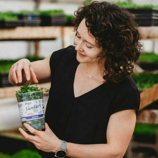 Cathy from Bramble Hill Farm holding FarmHers mix microgreen salad